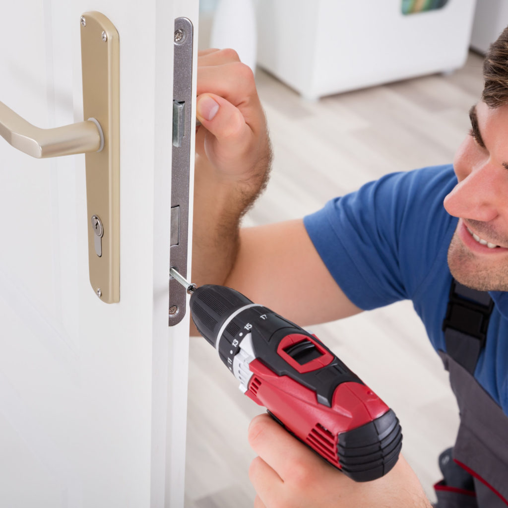 A locksmith upgrading a standard euro profile lock with a British standard 3 star lock