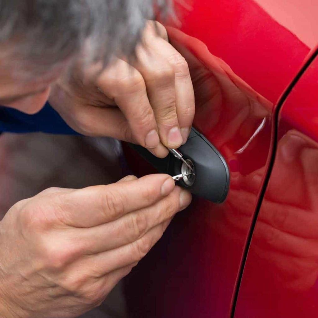 a key trouble locksmith opening a car door for a customer who locked their keys in the car