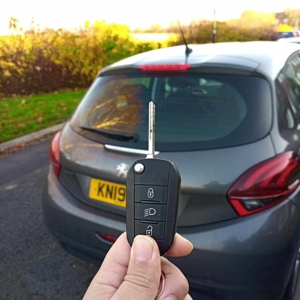auto locksmith holding up a replacement car key