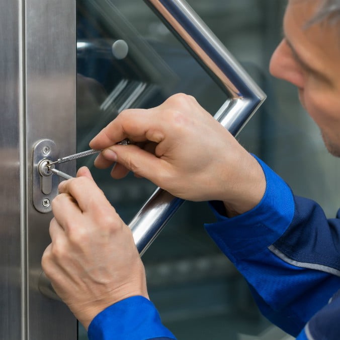 a key trouble locksmith using a lock pick to open a door for a customer